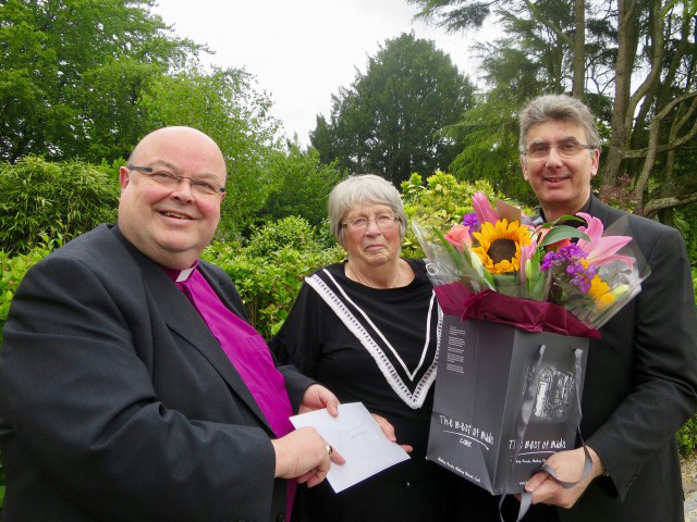 Miss Barbara Veitch receiving a presentation from the Bishop of Cork, and flowers from the Dean of Cork, following a lunch to mark her retirement.