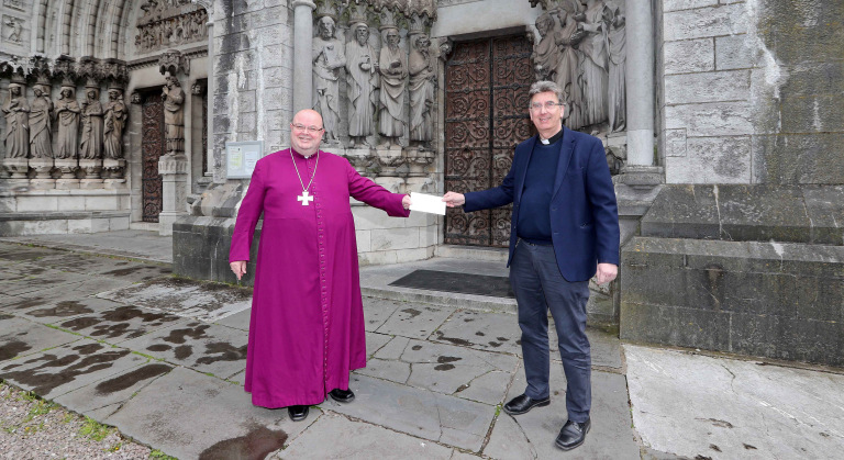 The Bishop of Cork, Cloyne and Ross, the Right Reverend Dr Paul Colton, presents a cheque to the Dean of Cork, the Very Reverend Nigel Dunne, at Saint Fin Barre's Cathedral, Cork. Picture: Jim Coughlan.