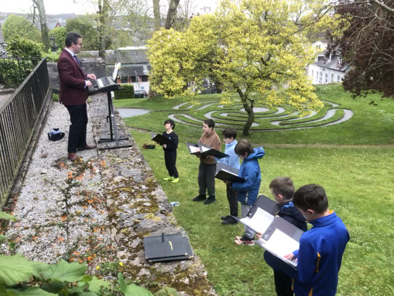 Some of the boy choristers of Saint Fin Barre's Cathedral, Cork, meet outside to rehearse near the Cathedral Labyrinth to rehearse under the direction of Mr Peter Stobart.