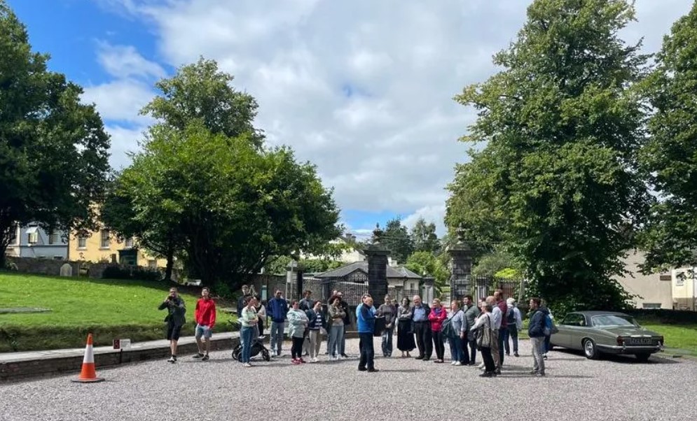 Visitors of St Fin Barre's Cathedral enjoying a guided tour of the grounds.