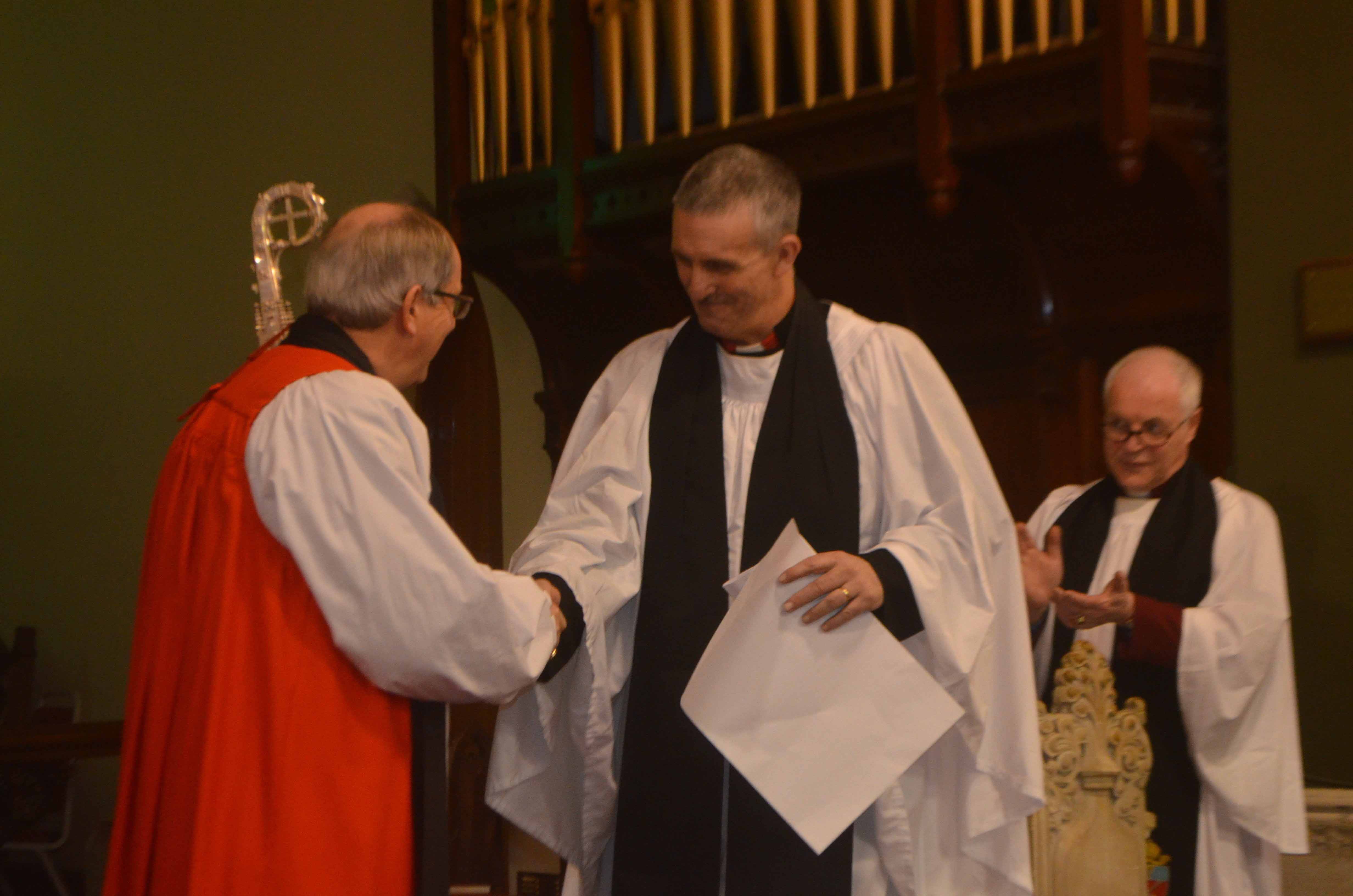 The Bishop of Derry and Raphoe, the Rt Rev Ken Good, congratulates the new rector of the parish of Camus-Juxta-Mourne, the Rev John White, watched by the Rural Dean for Omagh, the Rev Canon Robert Clarke.
