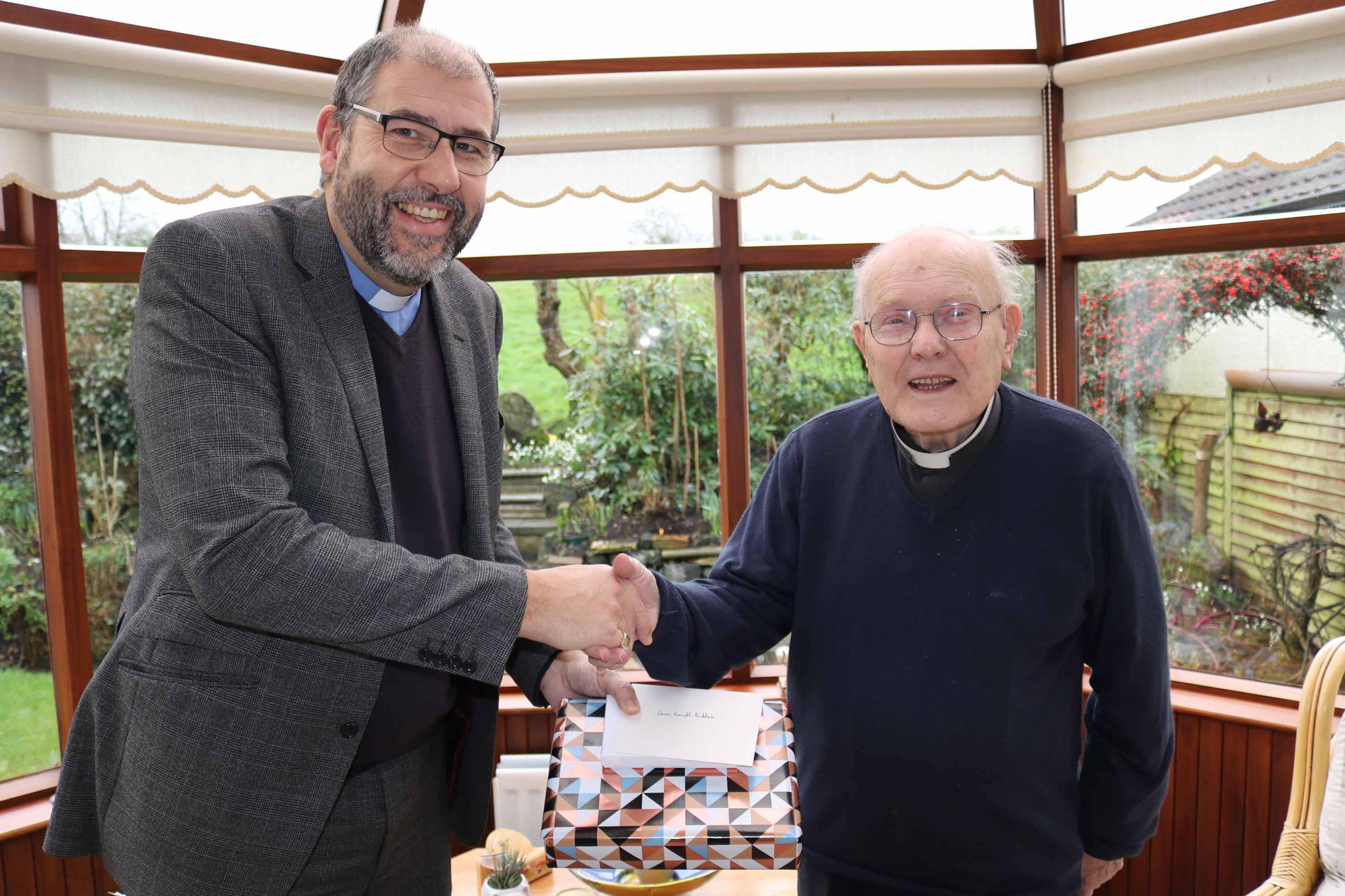 The Bishop of Connor's Commissary, Archdeacon George Davison, presents a gift to Canon Ken Ruddock as a thank you from the diocese on the occasion of his retirement.