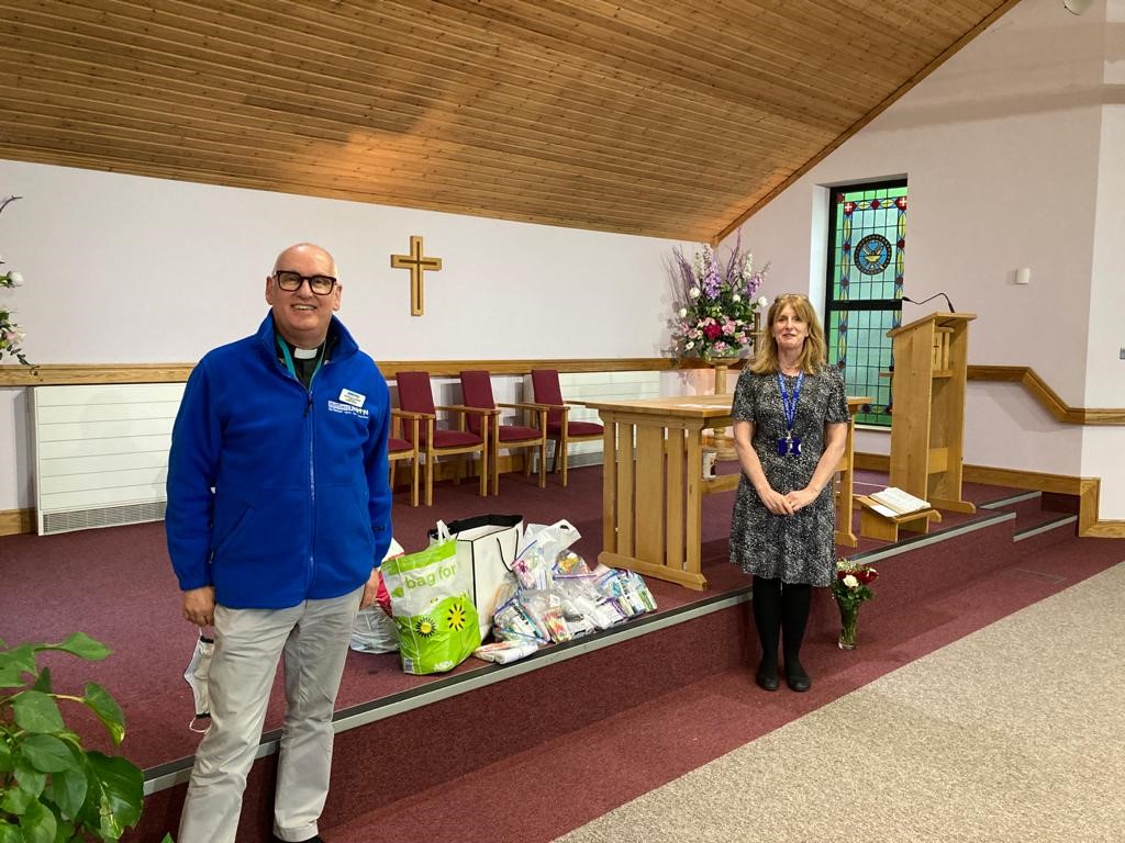 Archdeacon Stephen McBride, Connor MU Chaplain, delivers wash bags from Connor MU members to Hospital Chaplain Sanna Mallon in the church within Musgrave Park Hospital.